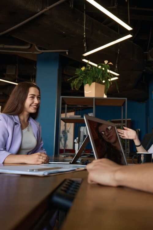 Friendly office team discussing workflow at a table in office
